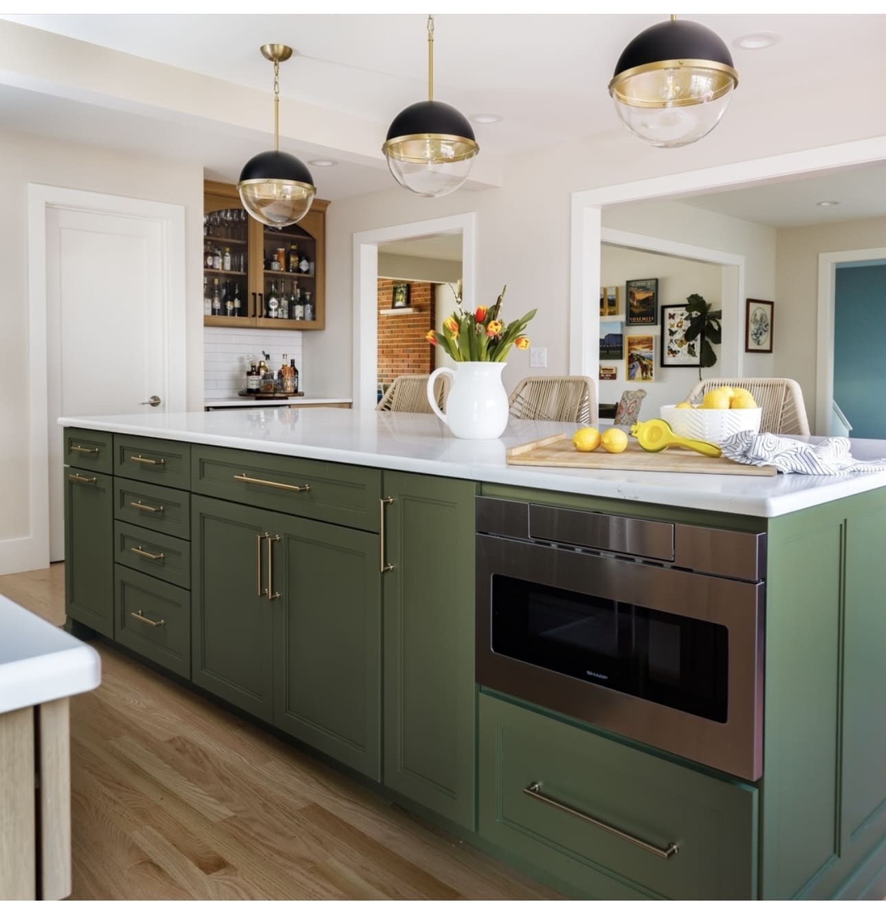Matte dark green island cabinets house a built-in microwave