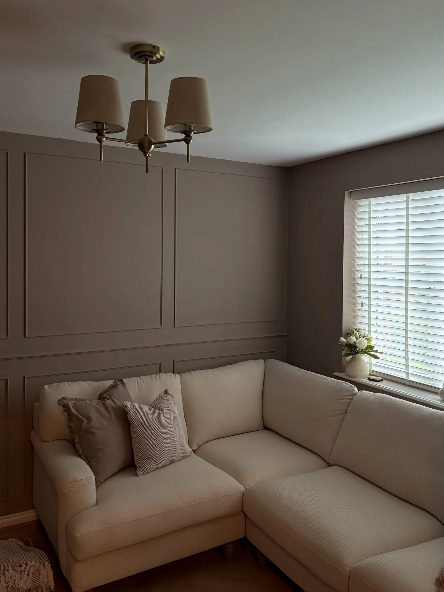 Incorporate Architectural Interest with Paneled Walls Behind Your Cream Sofa