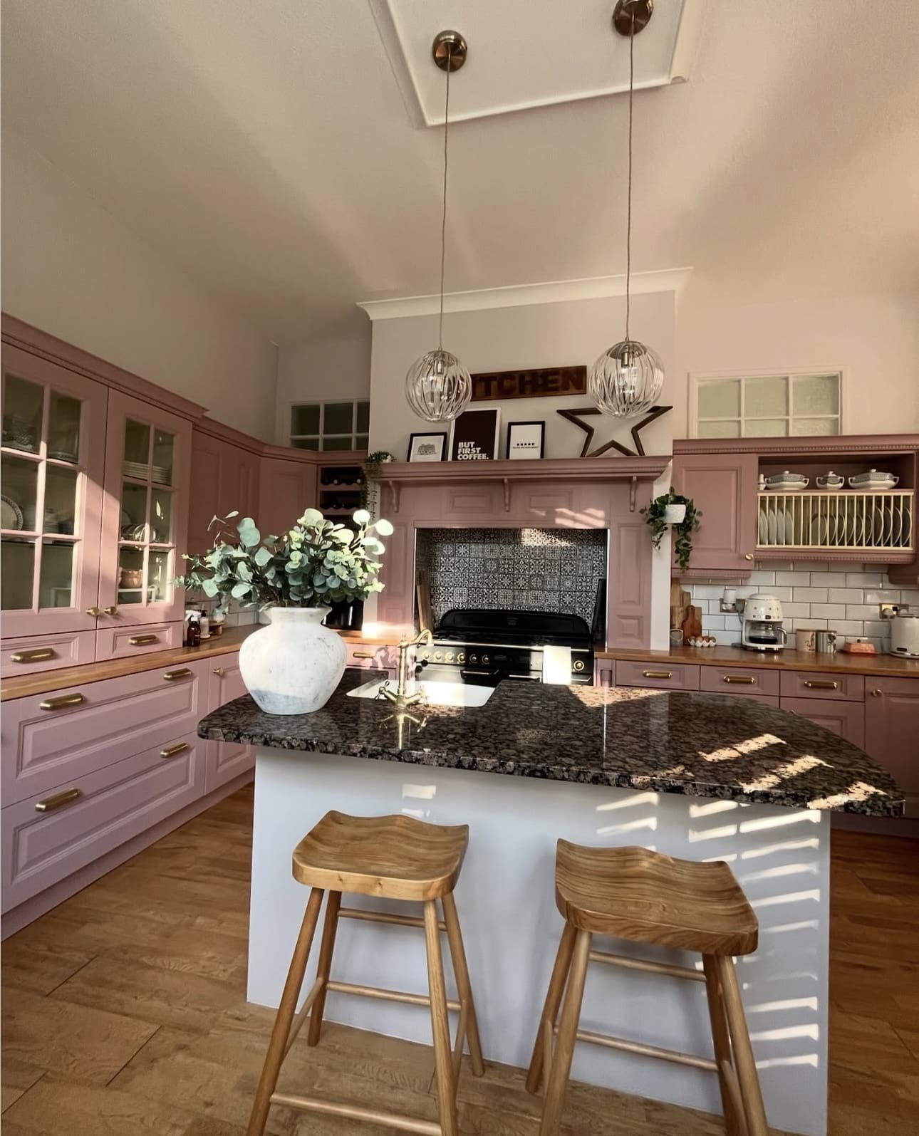 Wooden Stools Add Natural Warmth to a Pink Kitchen Island