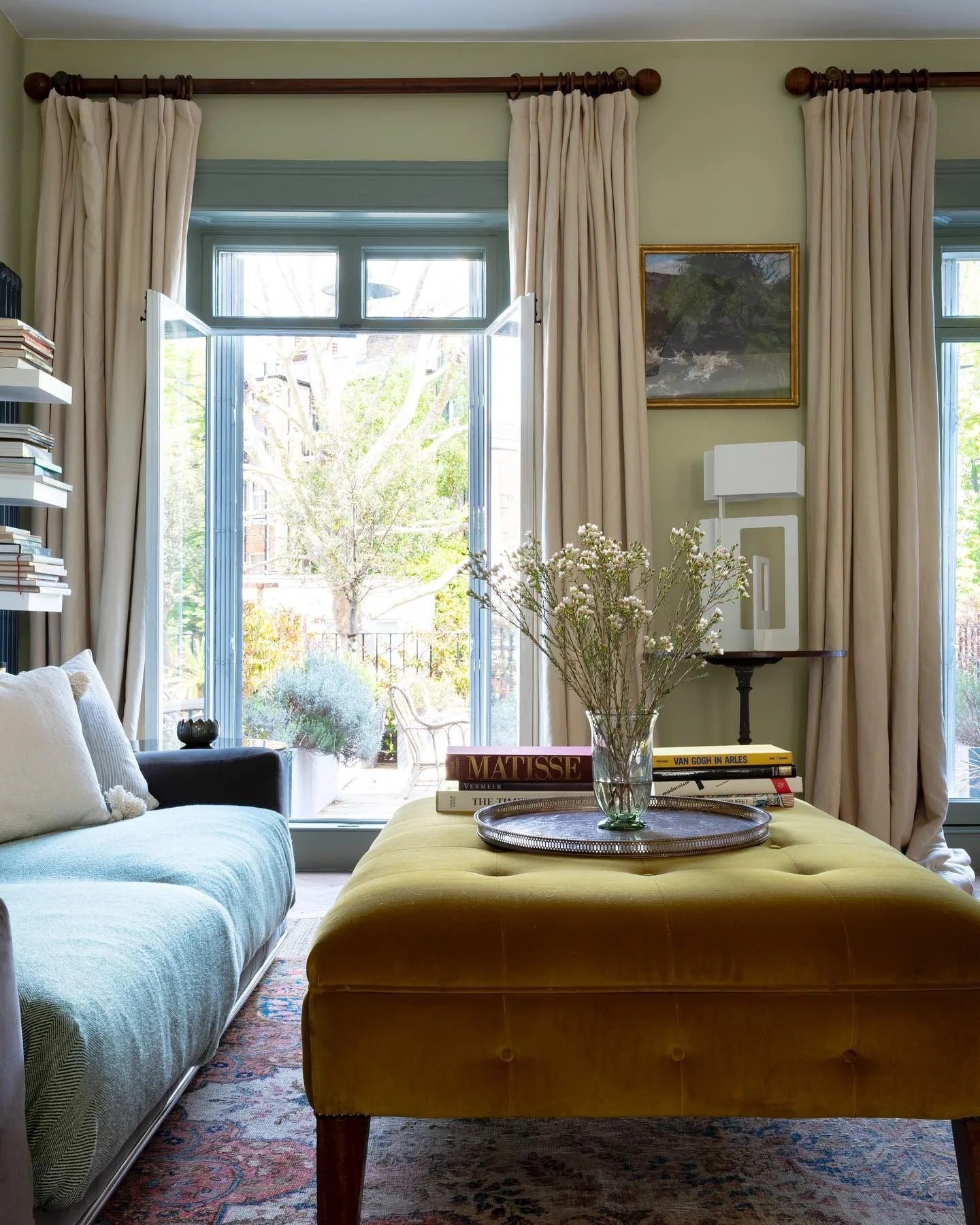 Tufted Yellow Ottoman Holds Stacked Art Books and Tray