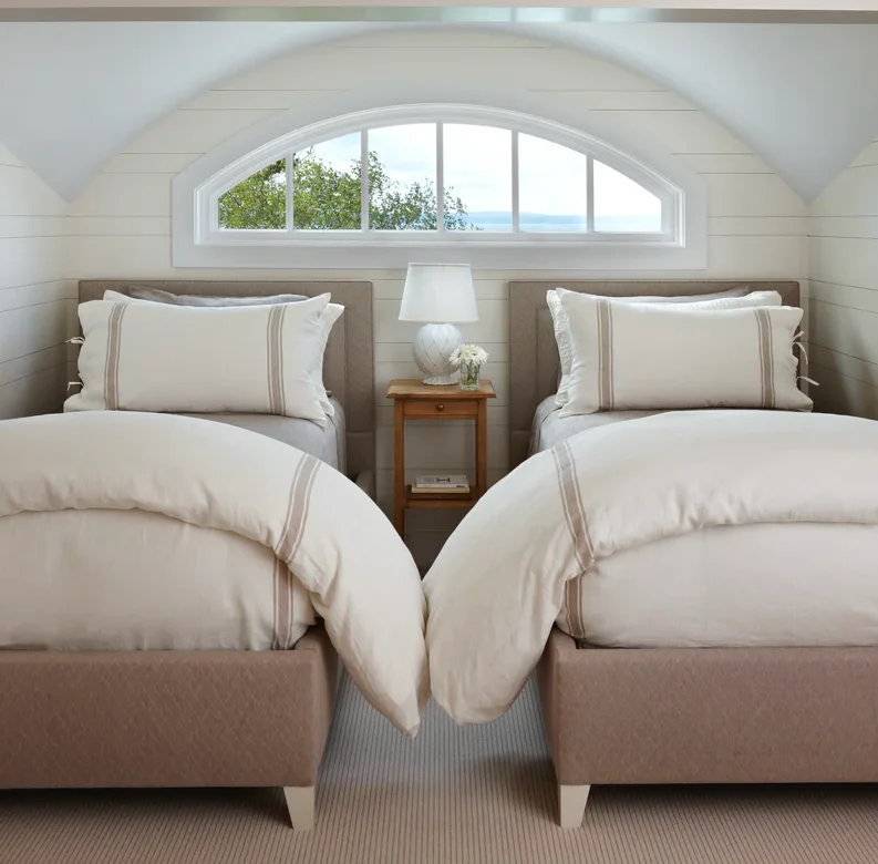 Neutral Bedding with Striped Accents for a Serene Room
