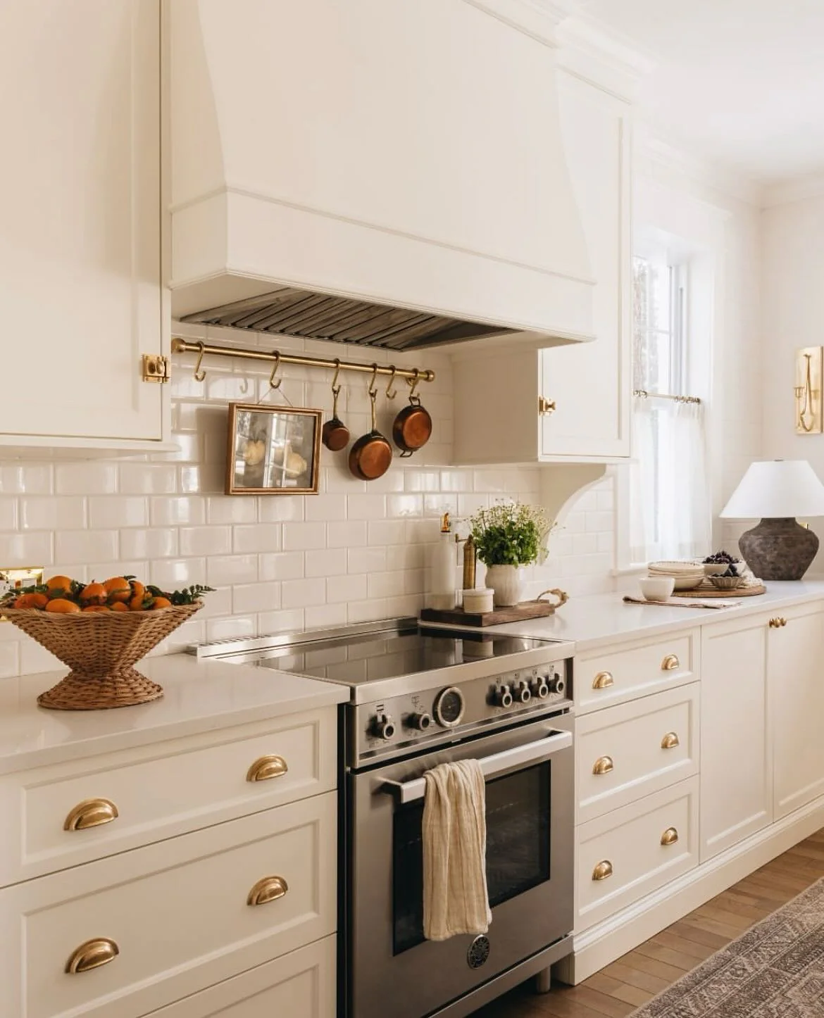 Brass pot rack displays small framed art above the range