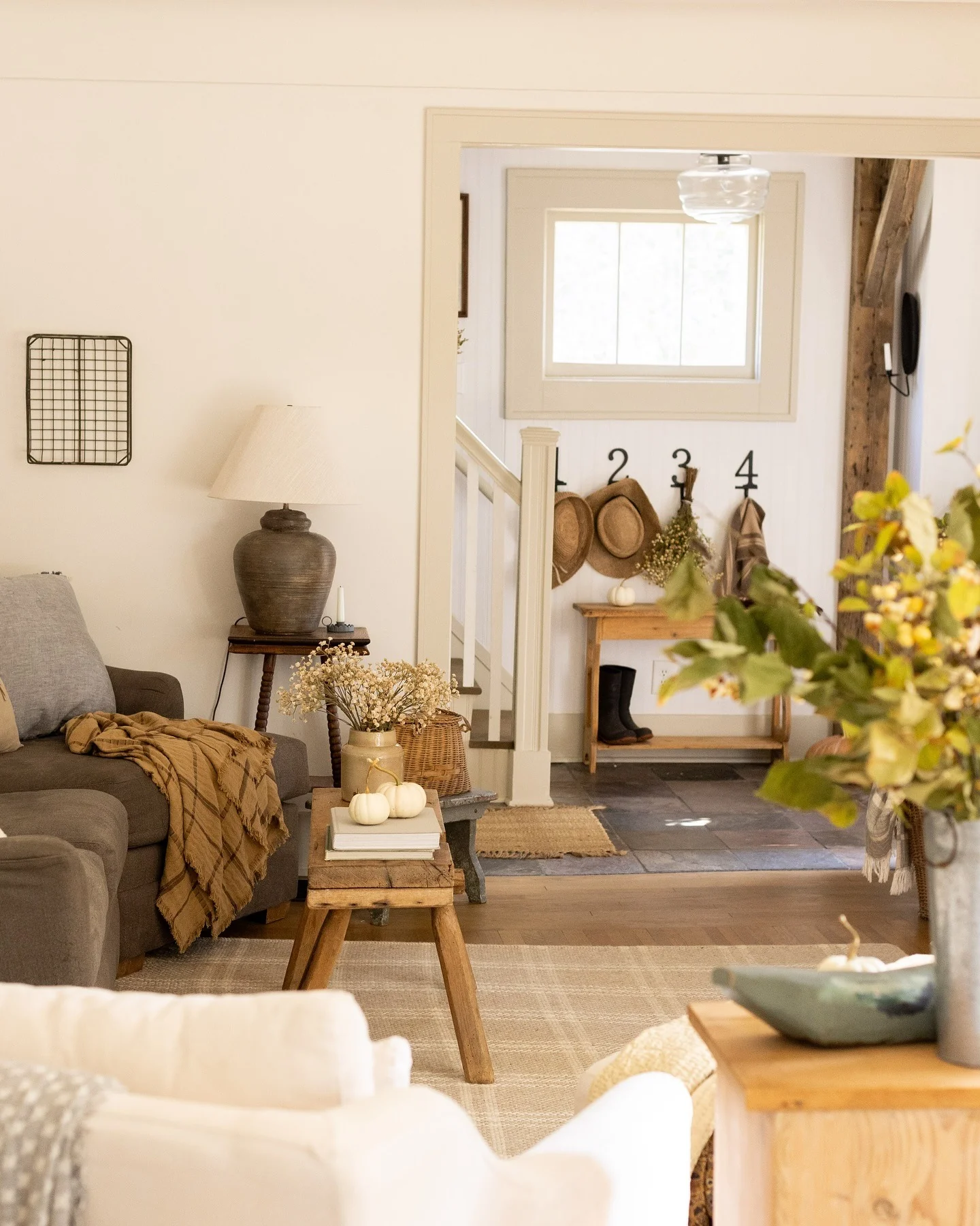 Rustic wooden stool anchors a cozy vignette with books and pumpkins