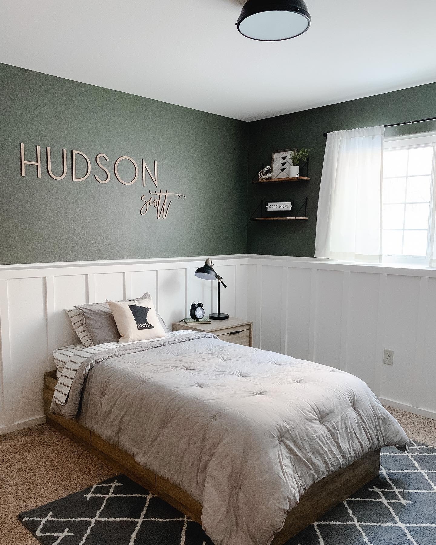 Wooden Name Sign Adds Personalized Touch Above the Bed