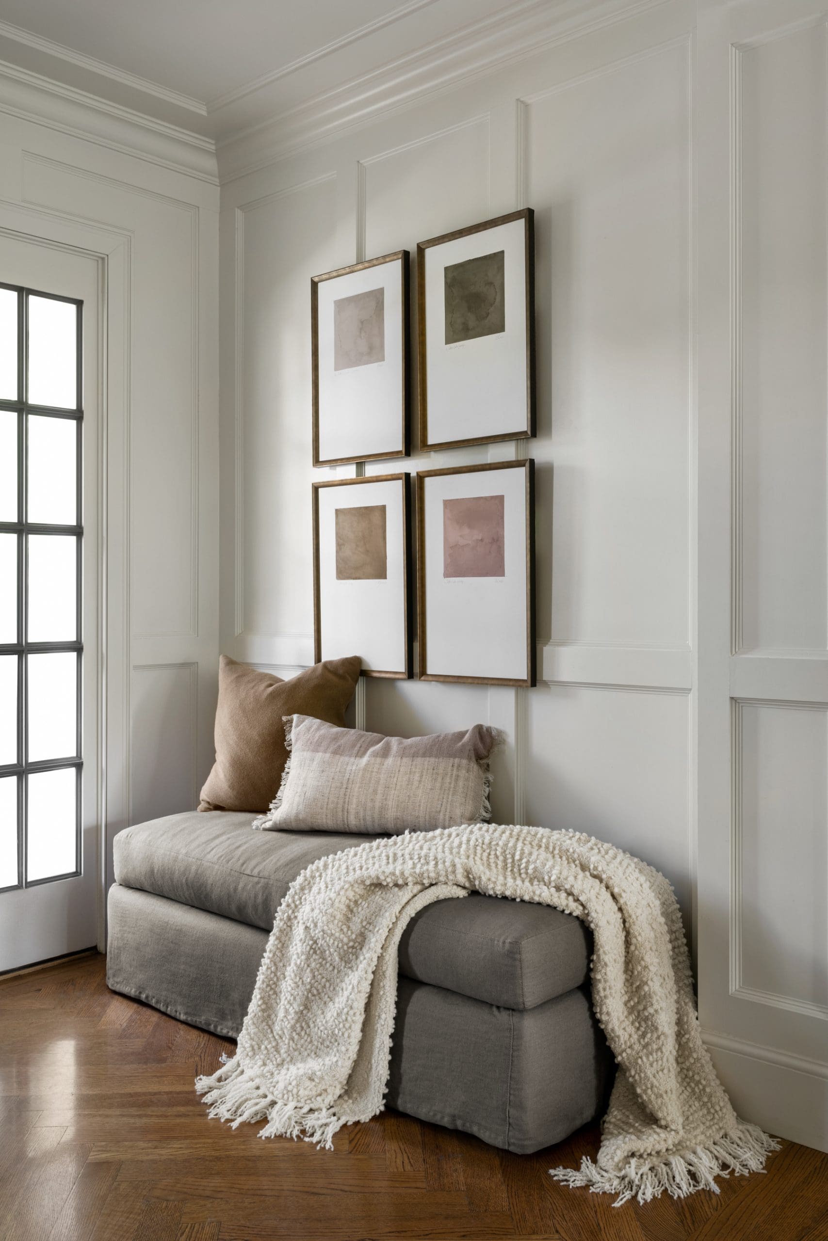 Four Framed Art Pieces Create a Gallery Wall Above Seating