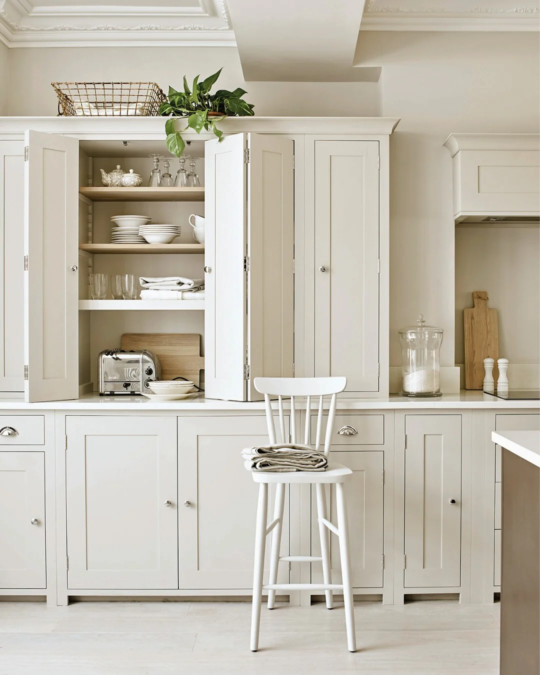 Open White Cabinets Reveal Neatly Stacked Dinnerware and Glassware