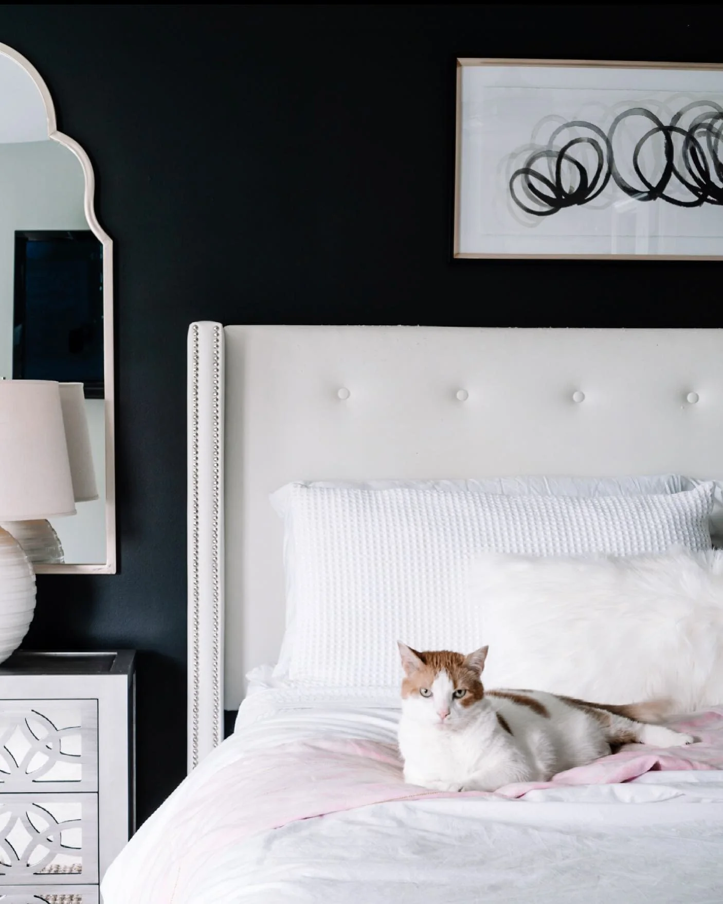 Black Walls Frame a White Tufted Headboard