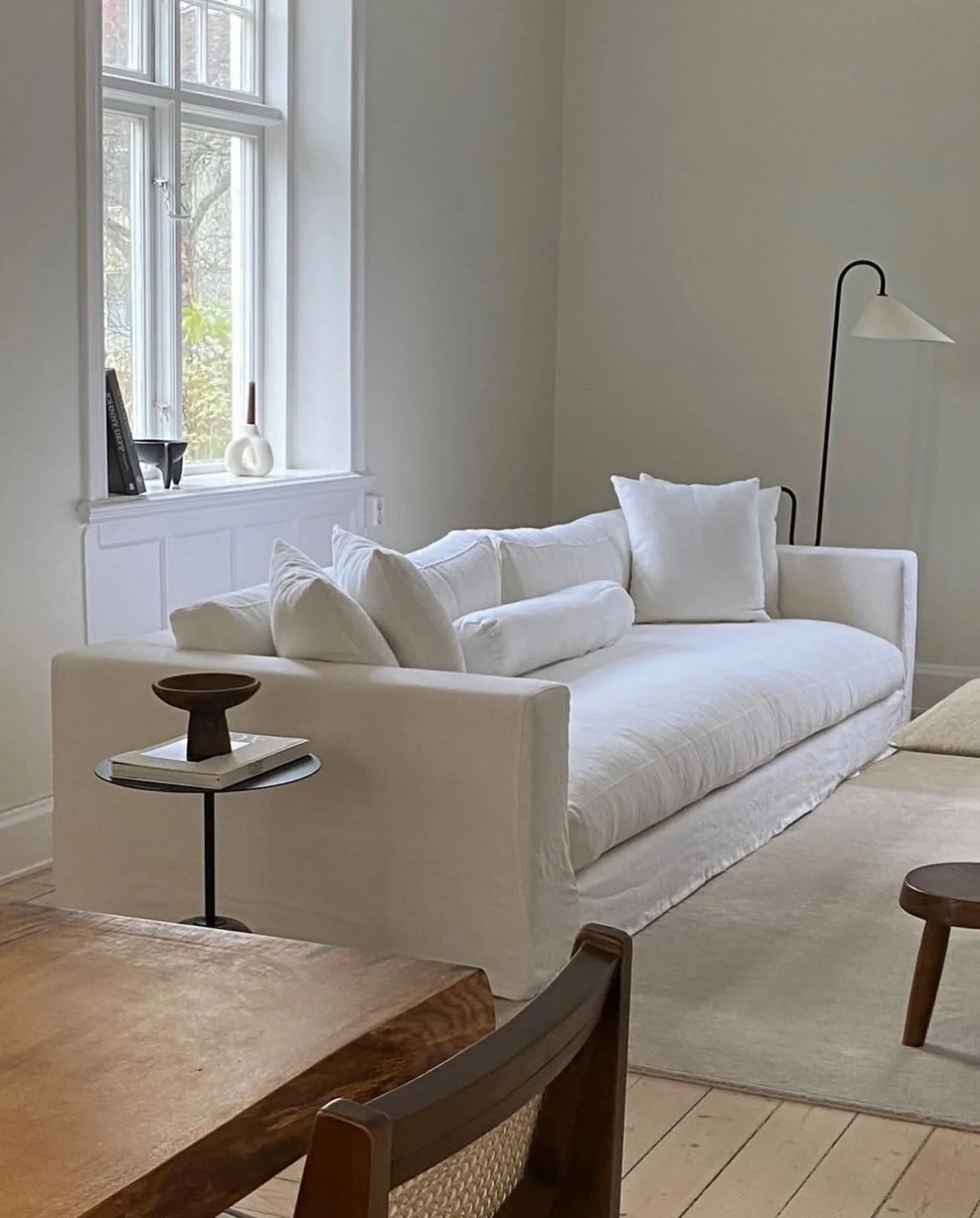 Minimalist Black Floor Lamp Arcs Over Sofa