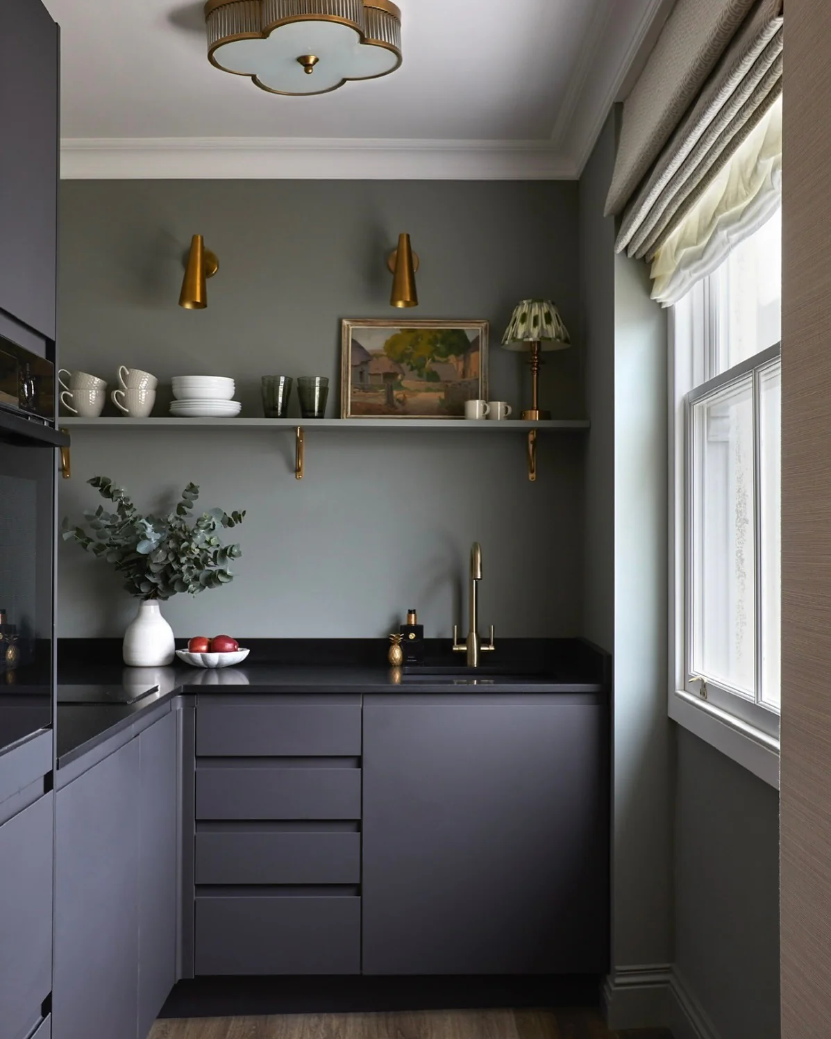 Brass Sconces Add Warm Task Lighting Above Open Shelves
