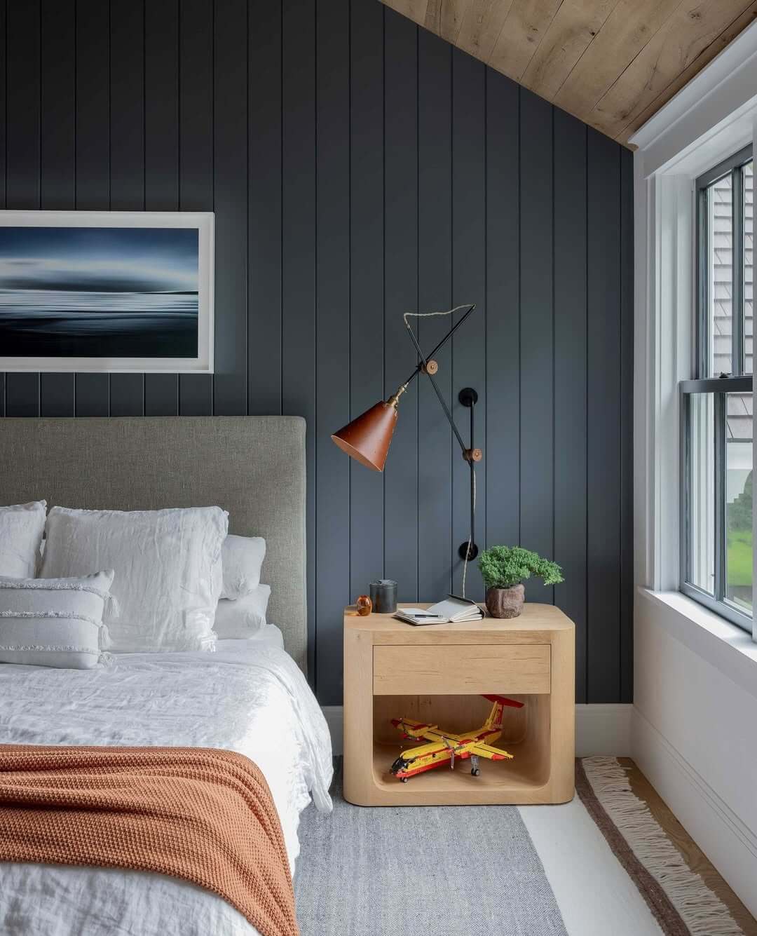 Dark Vertical Paneling Creates a Moody Bedroom Accent Wall