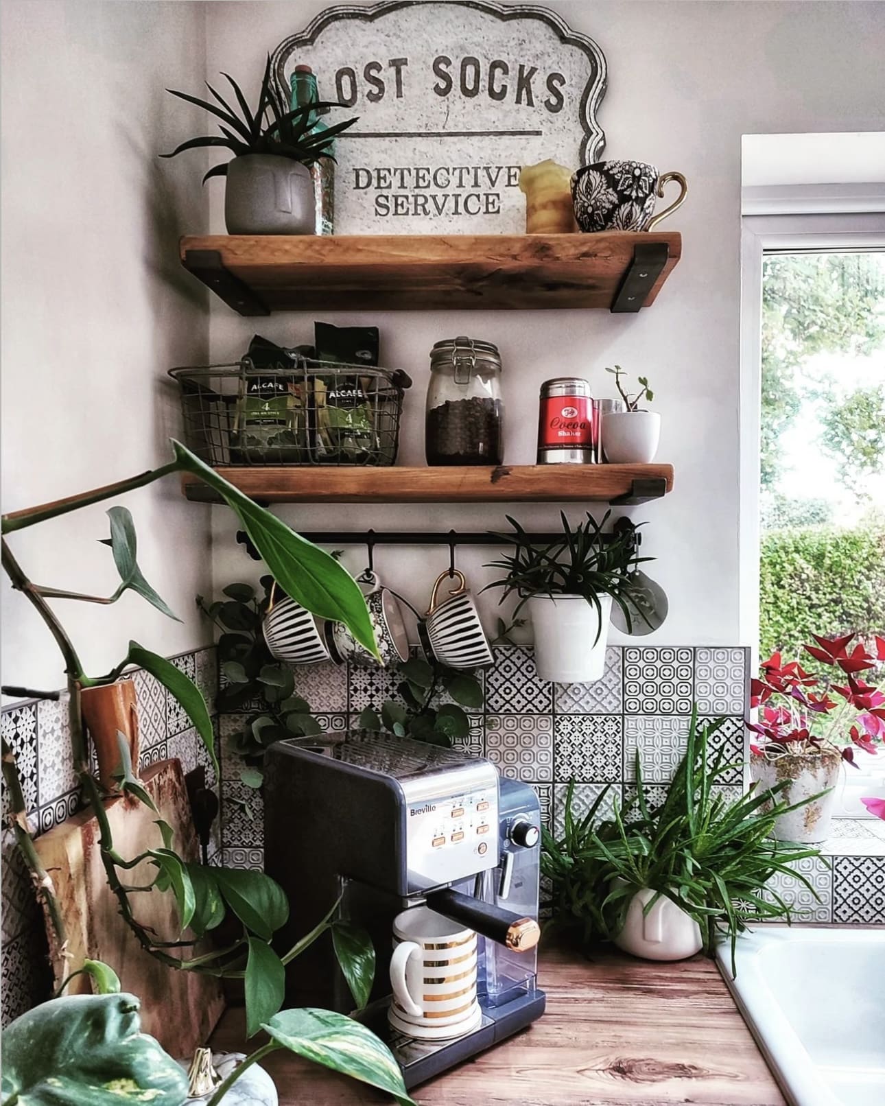 Black Metal Rod With S-Hooks Holds Mugs Above Patterned Tile
