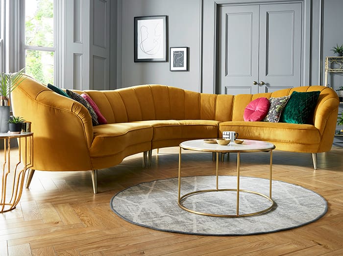 Curved Mustard Sofa Anchors a Grey Room