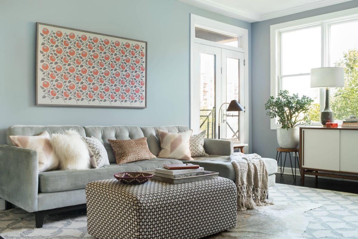 Grey Sofa With Patterned Ottoman and Textured Throws