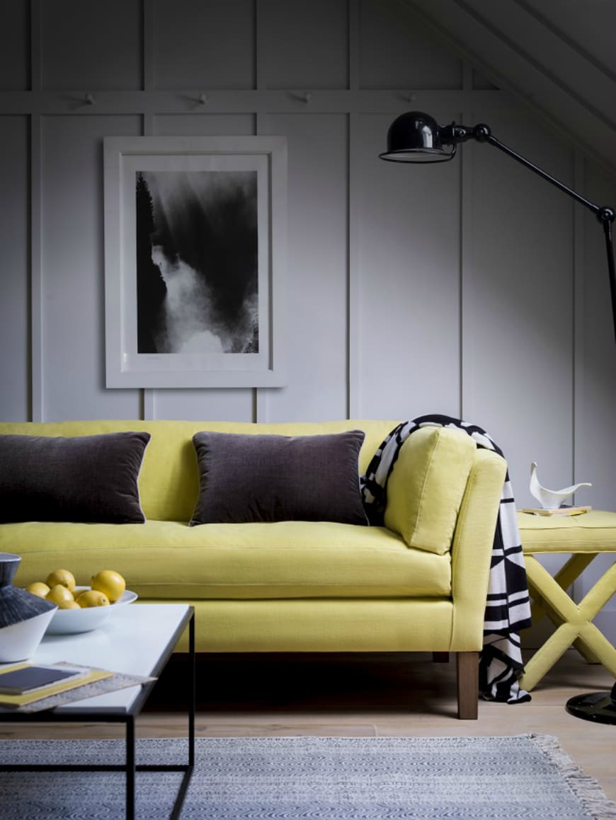 Bright Yellow Sofa With Charcoal Pillows and Graphic Throw