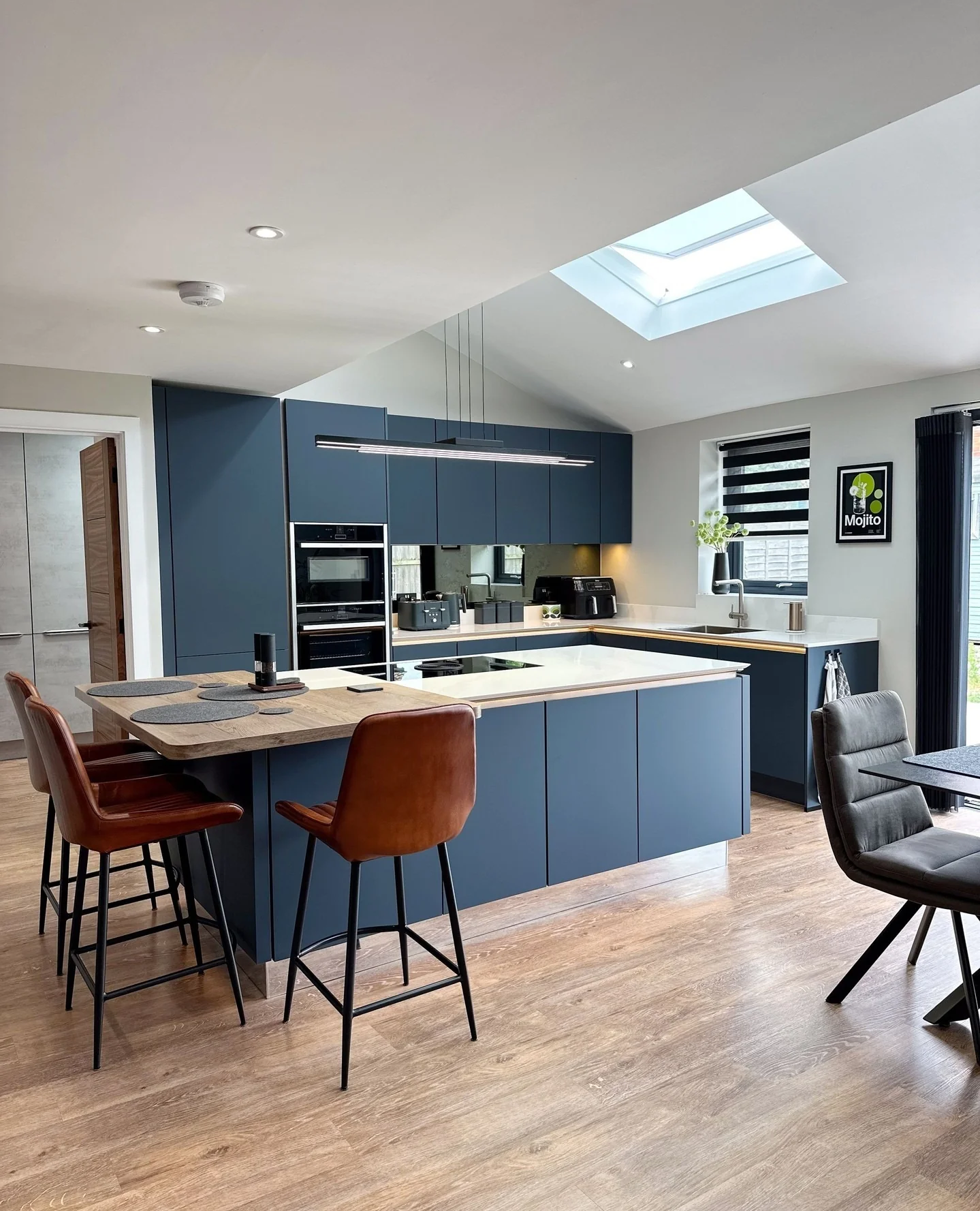 Deep Navy Cabinets and Mirrored Backsplash for Depth