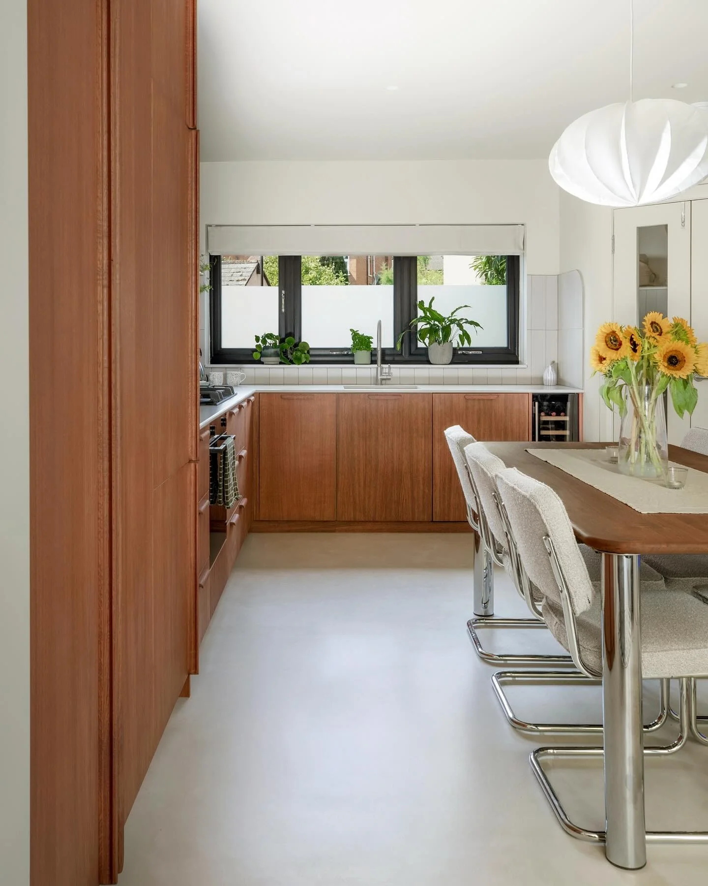 Tall Walnut Cabinets Create a Seamless Mid-Century Kitchen Wall
