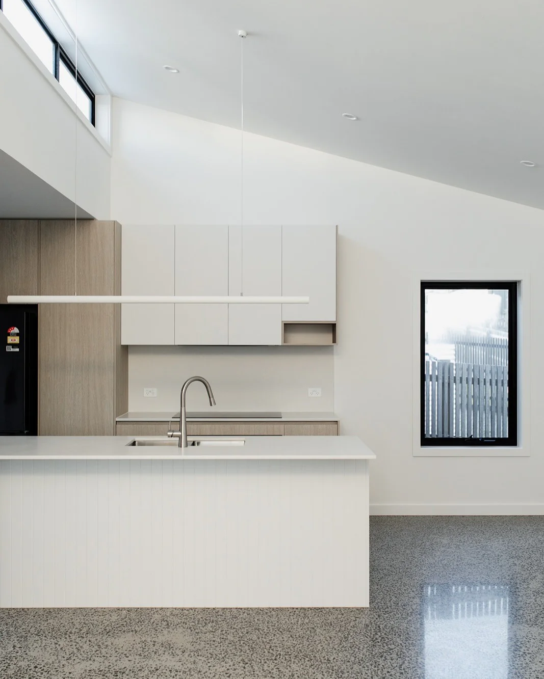 Minimalist pendant light defines the kitchen island