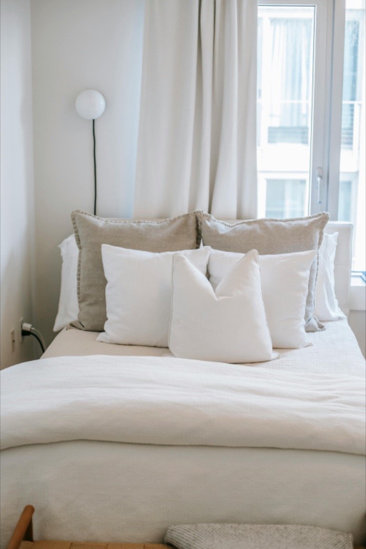 Layered Linen Pillows Create Cozy Depth on Neutral Bed