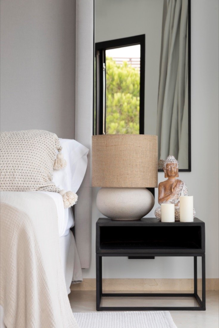 Buddha Statue and Candles Add Serene Accents to a Black Nightstand