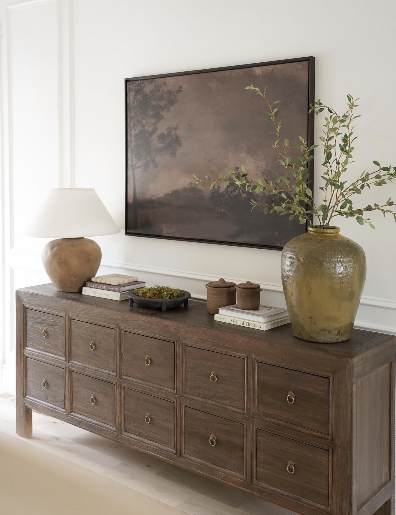 Dark Landscape Art Above a Long, Low Console