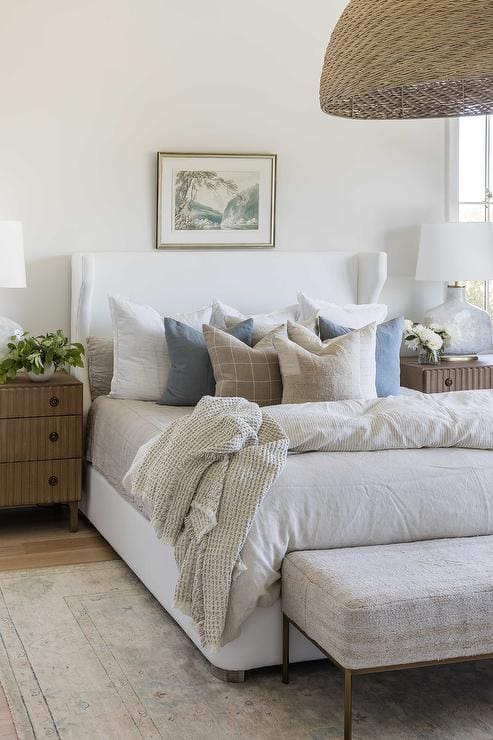 Layered Pillows Add Cozy Texture to a White Wingback Headboard