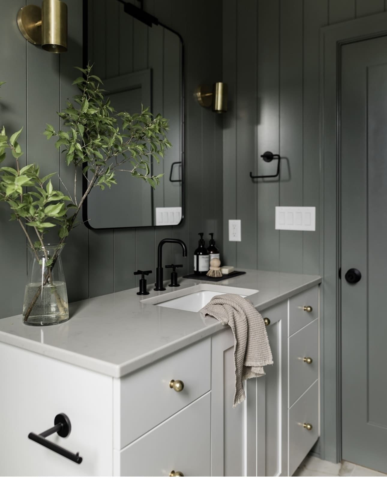 Warm Up Paneled Walls with Cylindrical Brass Sconces