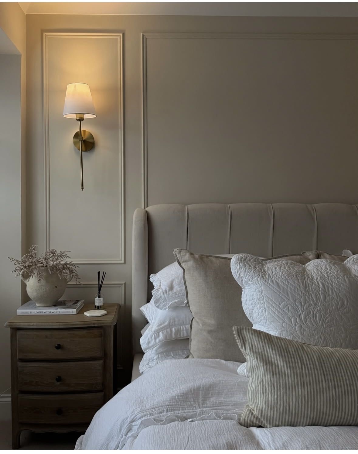Brass Sconce Illuminates Bedside Vignette