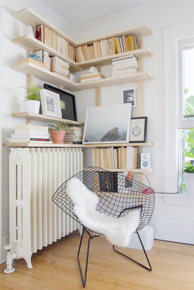Light Wood Shelves Create a Cozy Reading Nook Around a Radiator