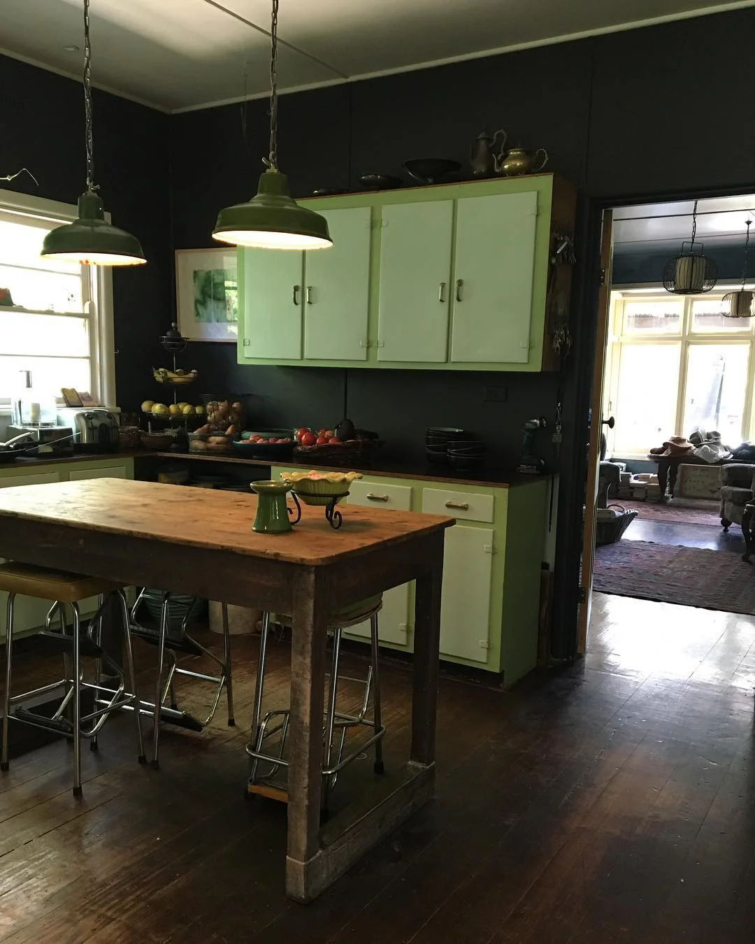 Sage Green Cabinets Offer a Fresh Contrast to Dark Walls
