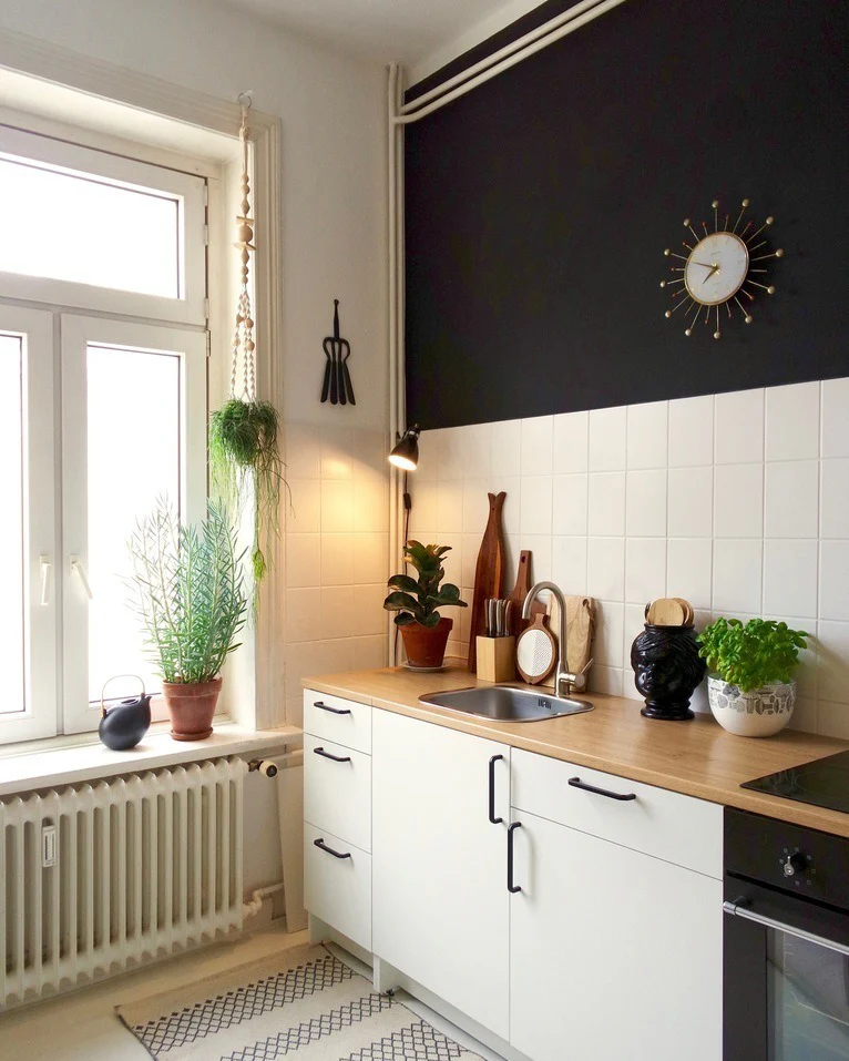 Black Walls Add Dramatic Contrast Above a White Tile Backsplash