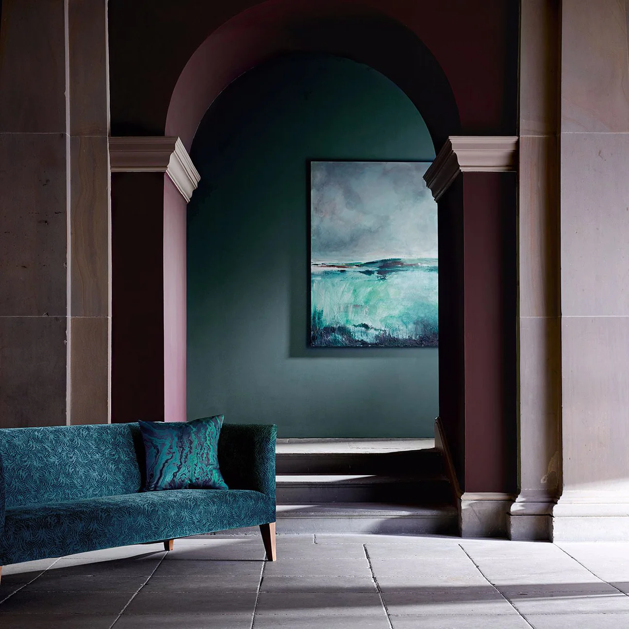 Deep Teal Sofa Anchors a Moody Hallway With Art