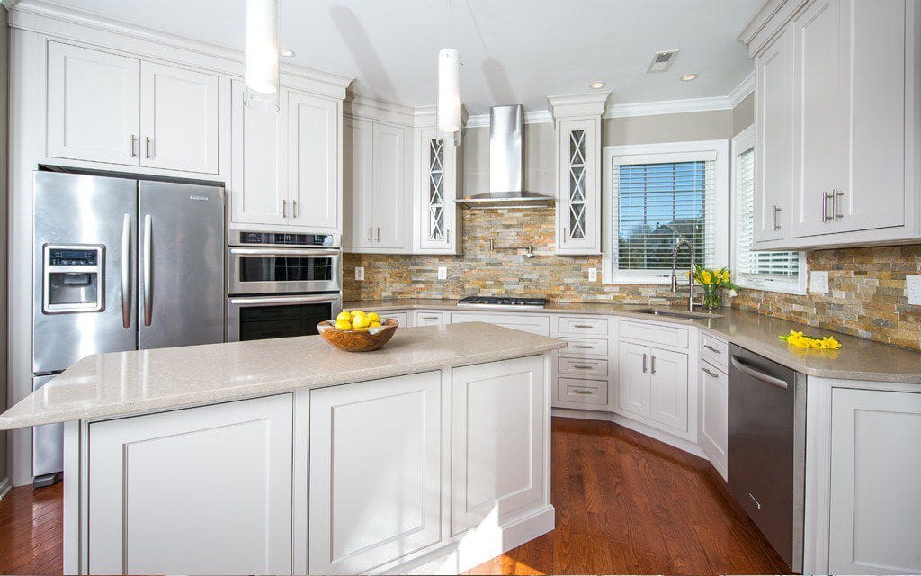 Stacked Stone Backsplash Adds Warm Texture Behind White Cabinets