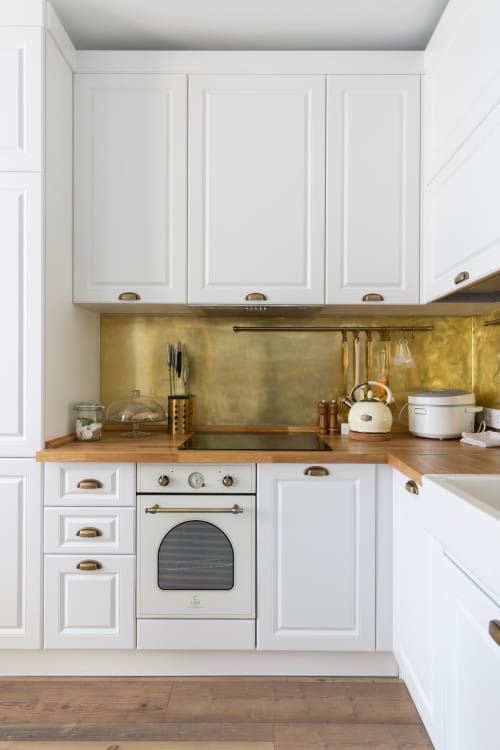 Gold Metallic Backsplash Adds Warmth Behind White Cabinets