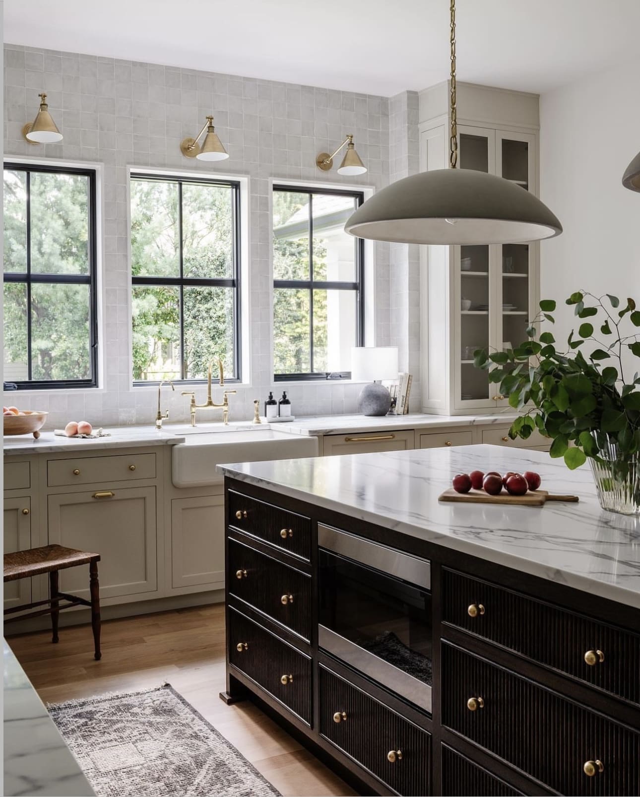 Brass Sconces Add Warm Task Lighting Above Square-Tiled Backsplash