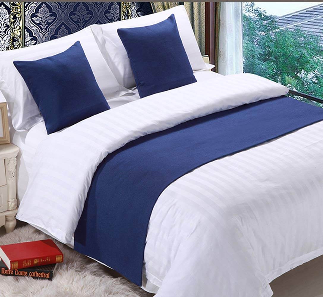 Layer a Navy Bed Runner for Depth Against White Linens