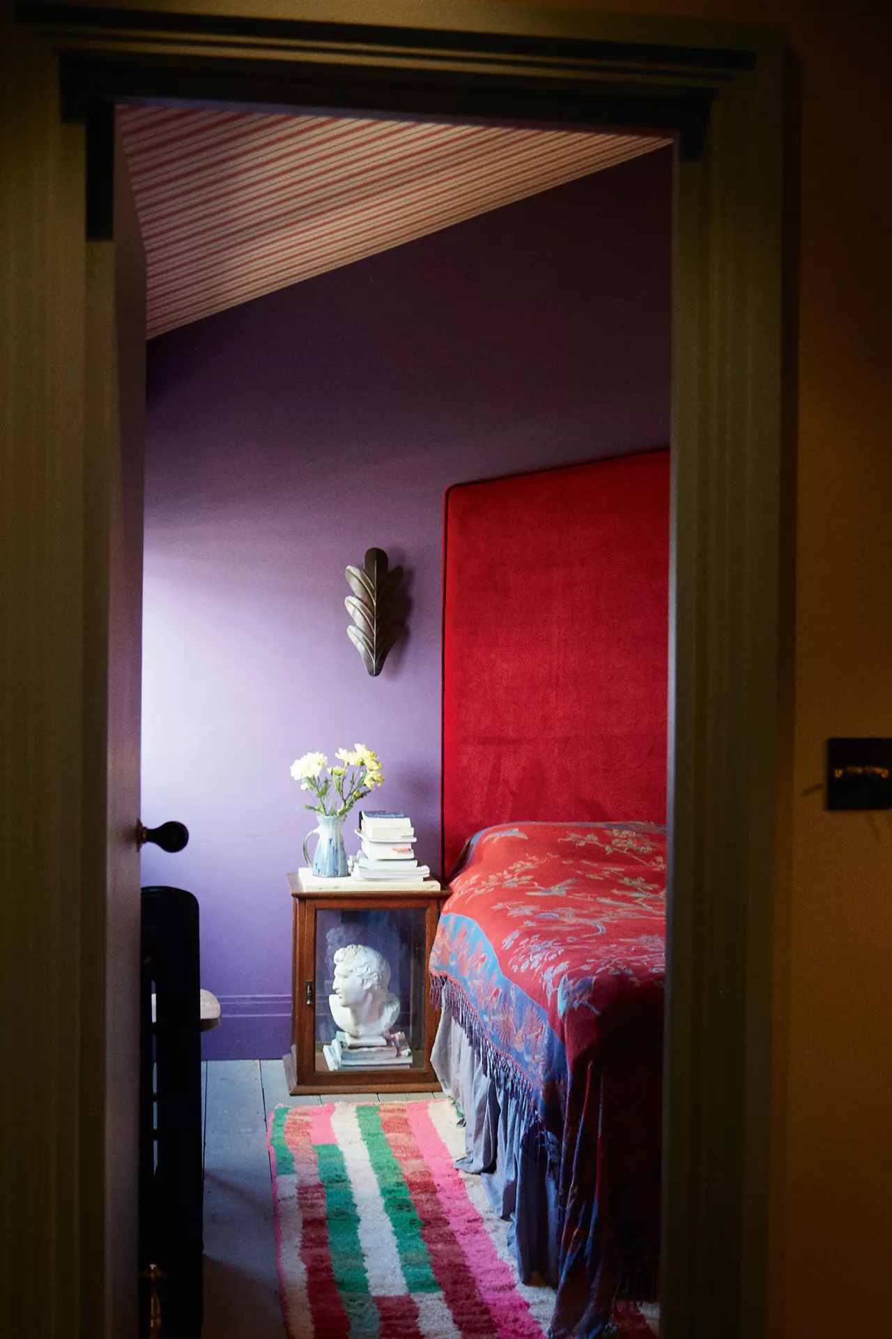 Purple Walls with a Dramatic Red Headboard