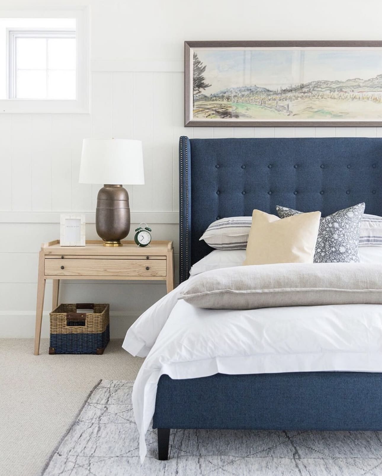 Tufted Navy Headboard Anchors Artwork and Pillows
