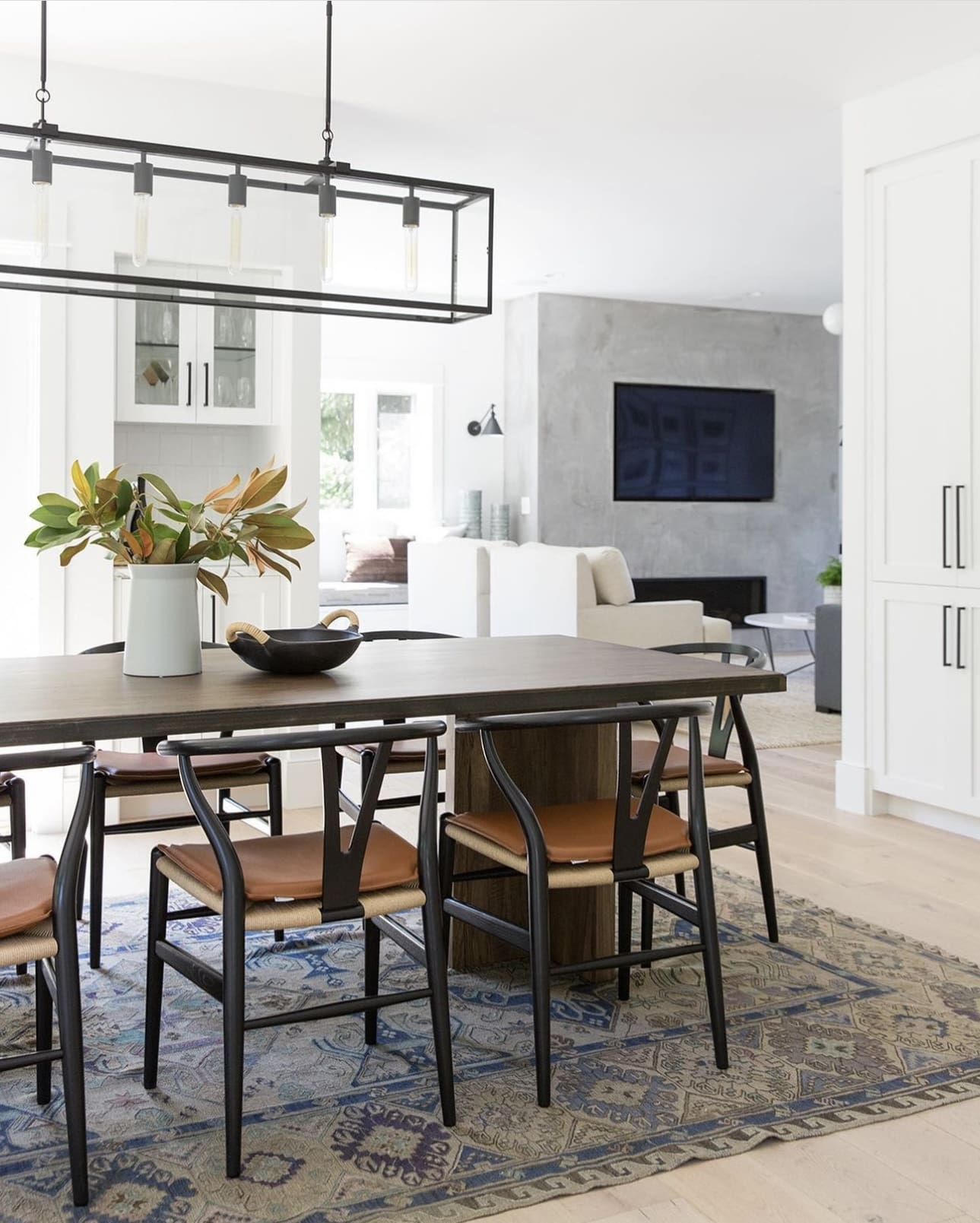 Dark Wishbone Chairs Frame the Neutral Patterned Rug
