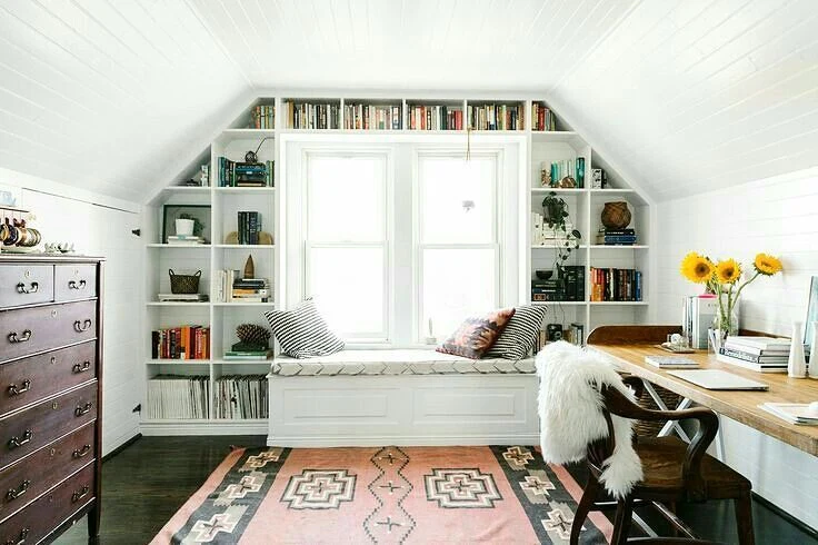 Built-in Shelves Frame a Window Seat for an Attic Office