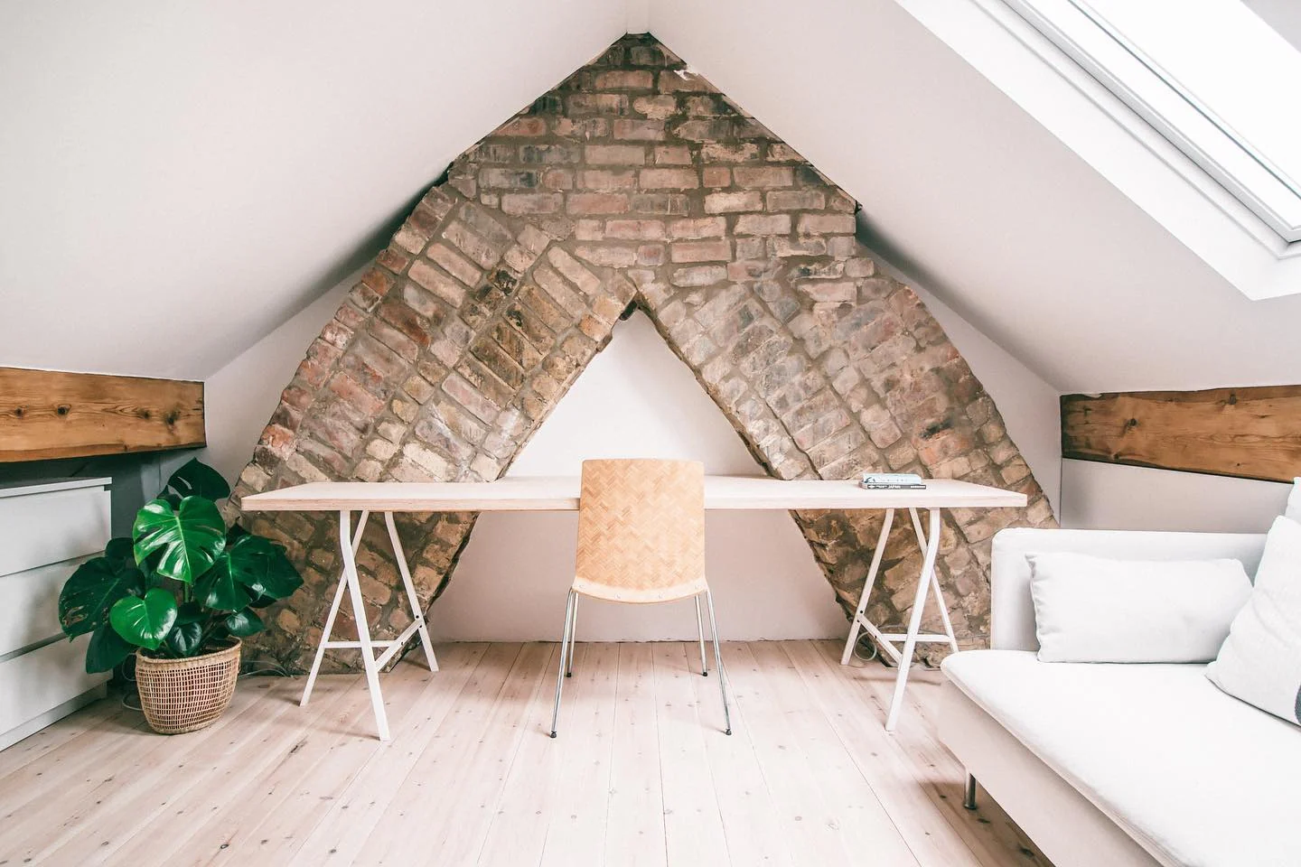 Exposed Brick Archway Frames a Minimalist Attic Office