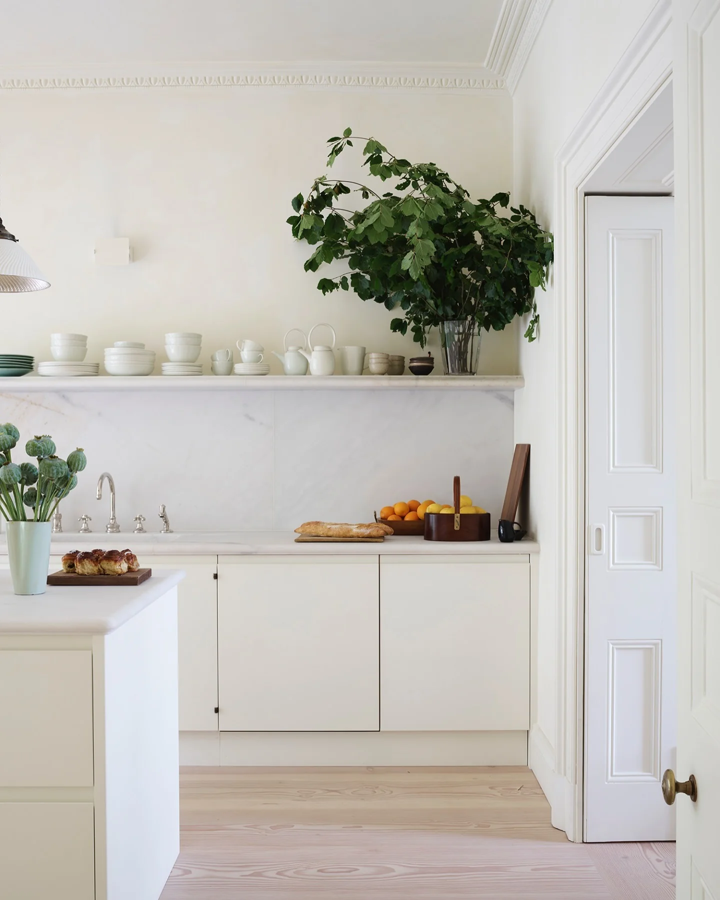 Dramatic Greenery Fills a Clear Vase on Open Shelving