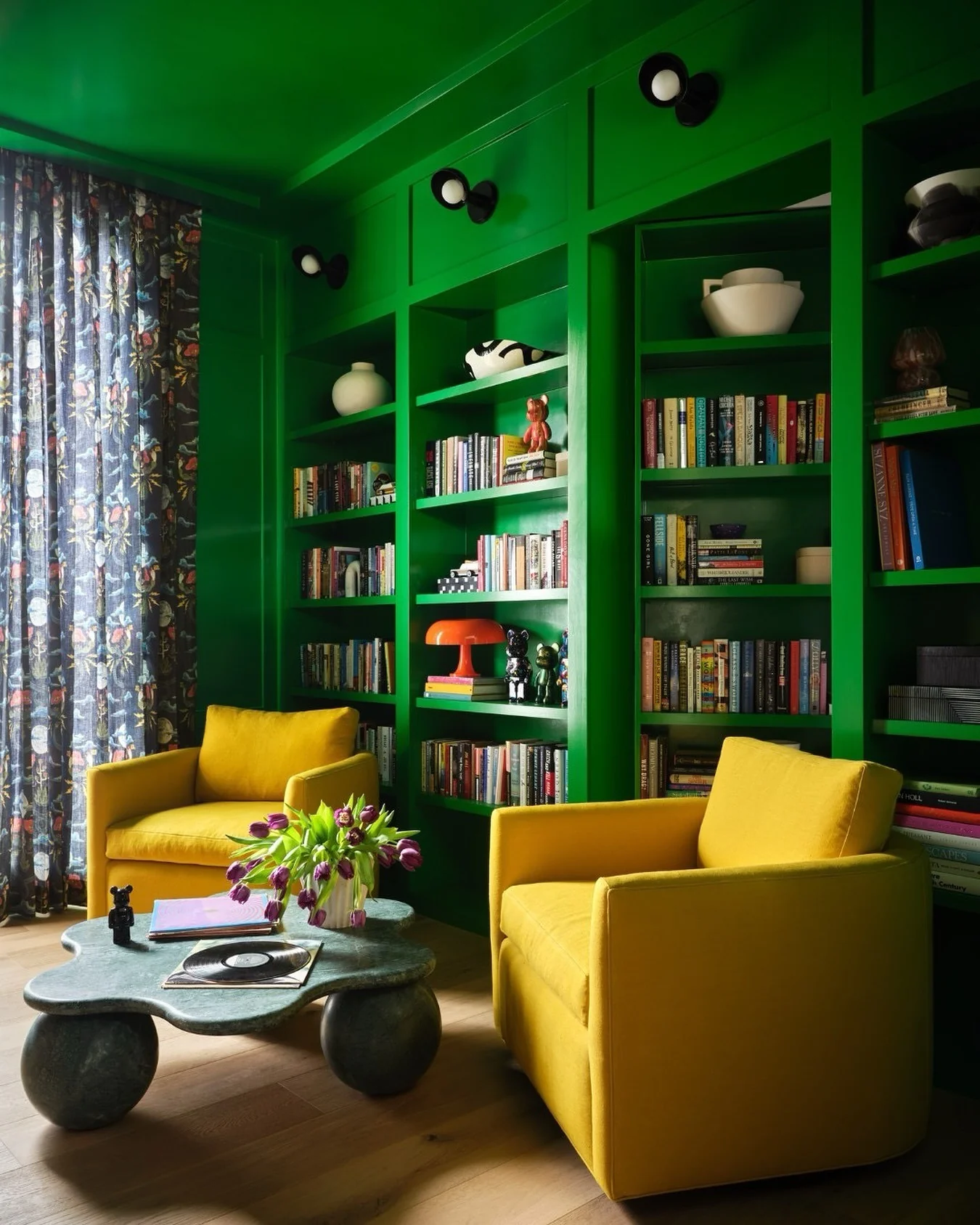 Black Sconces Illuminate Green Built-In Shelving