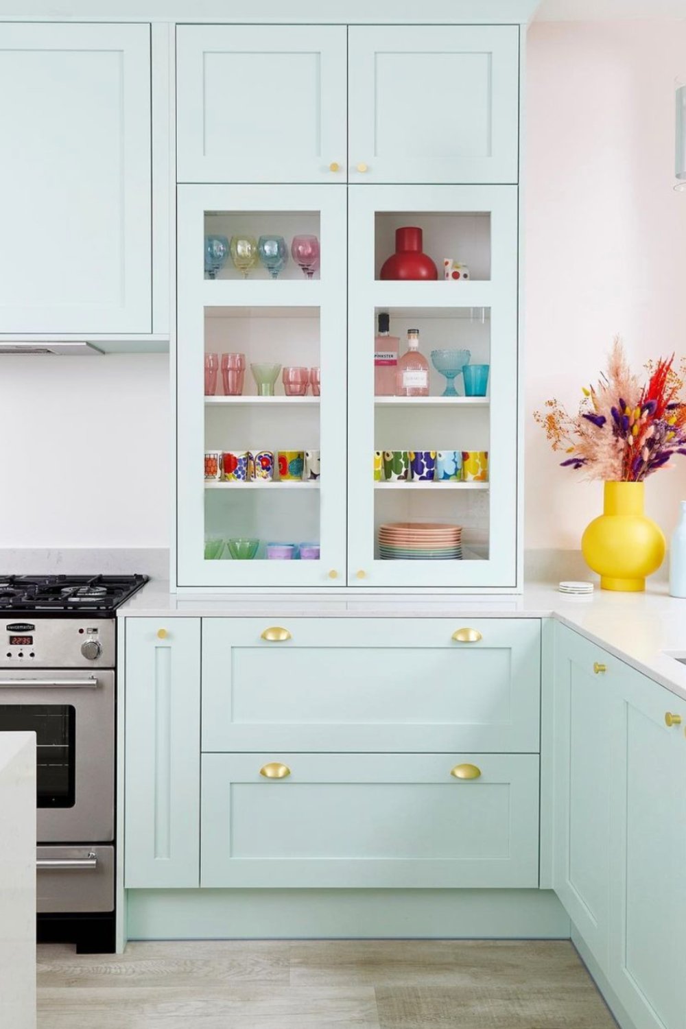 Pale Mint Cabinets with Curved Brass Pulls for a Fresh Feel