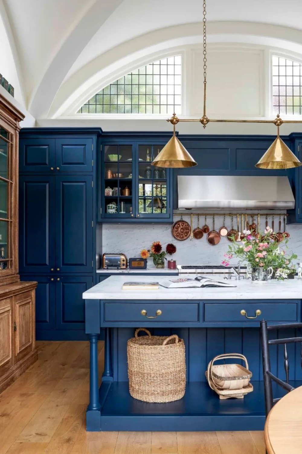 Deep Navy Blue Cabinets Frame a Warm Brass Pot Rack