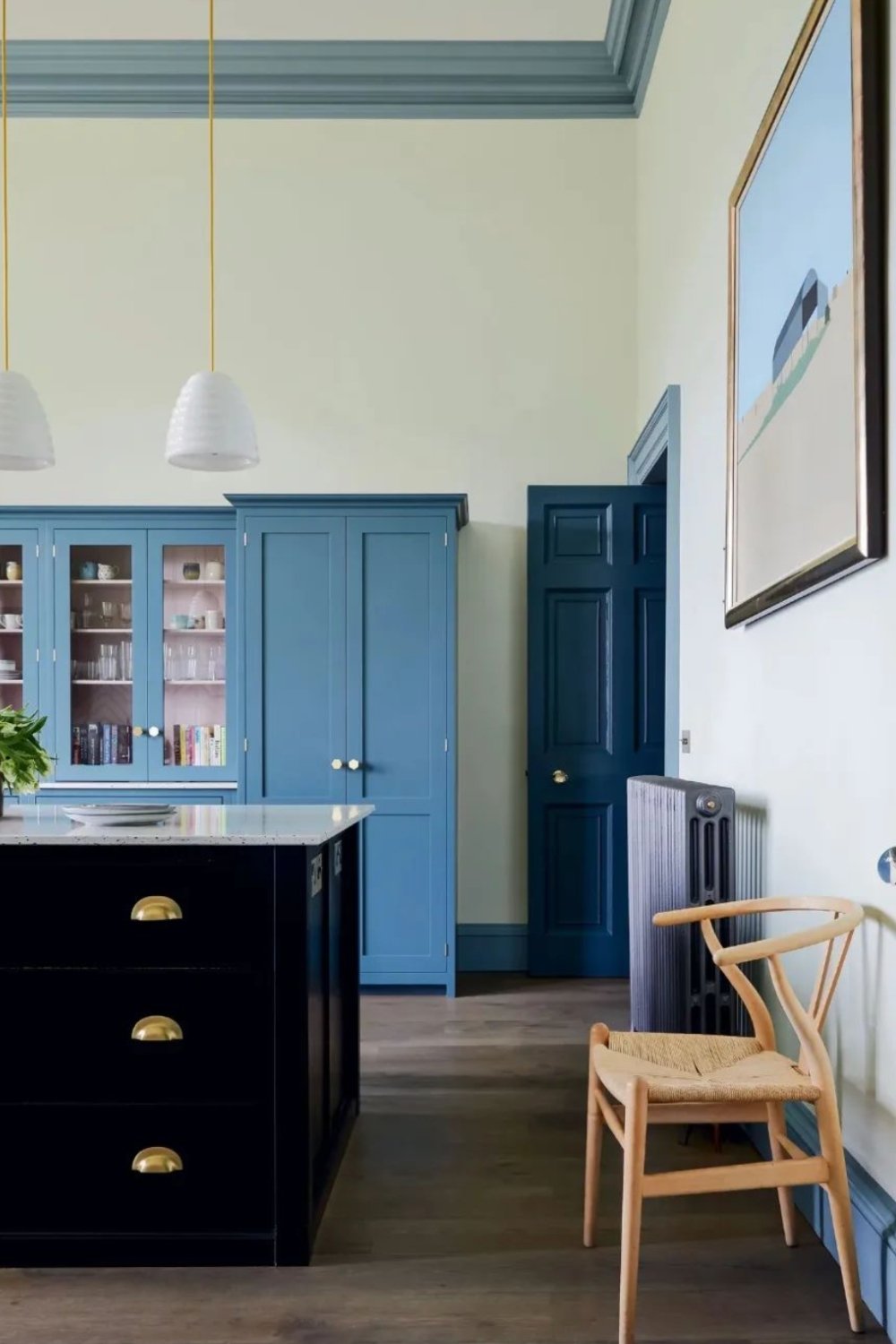 Deep Blue Island Cabinets with Brass Pulls Ground the Space