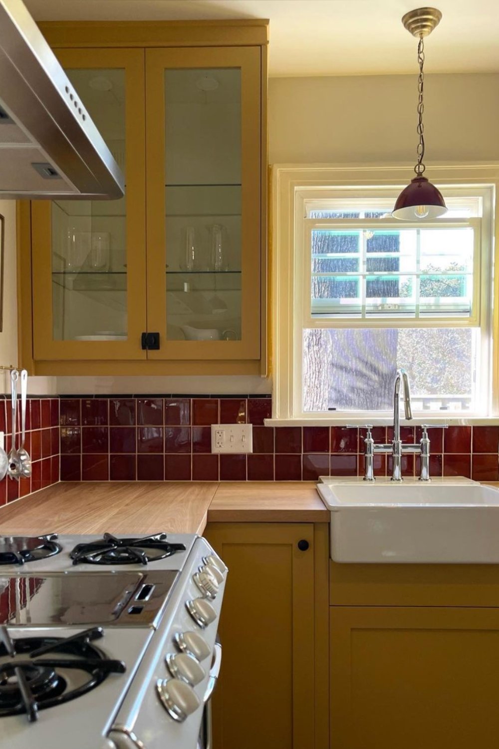 Warm Mustard Cabinets Pair with Deep Red Square Tile Backsplash