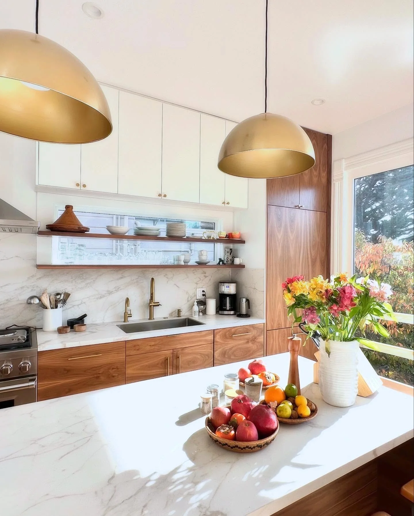 Warm Wood Cabinets Add Richness Above Marble Countertops