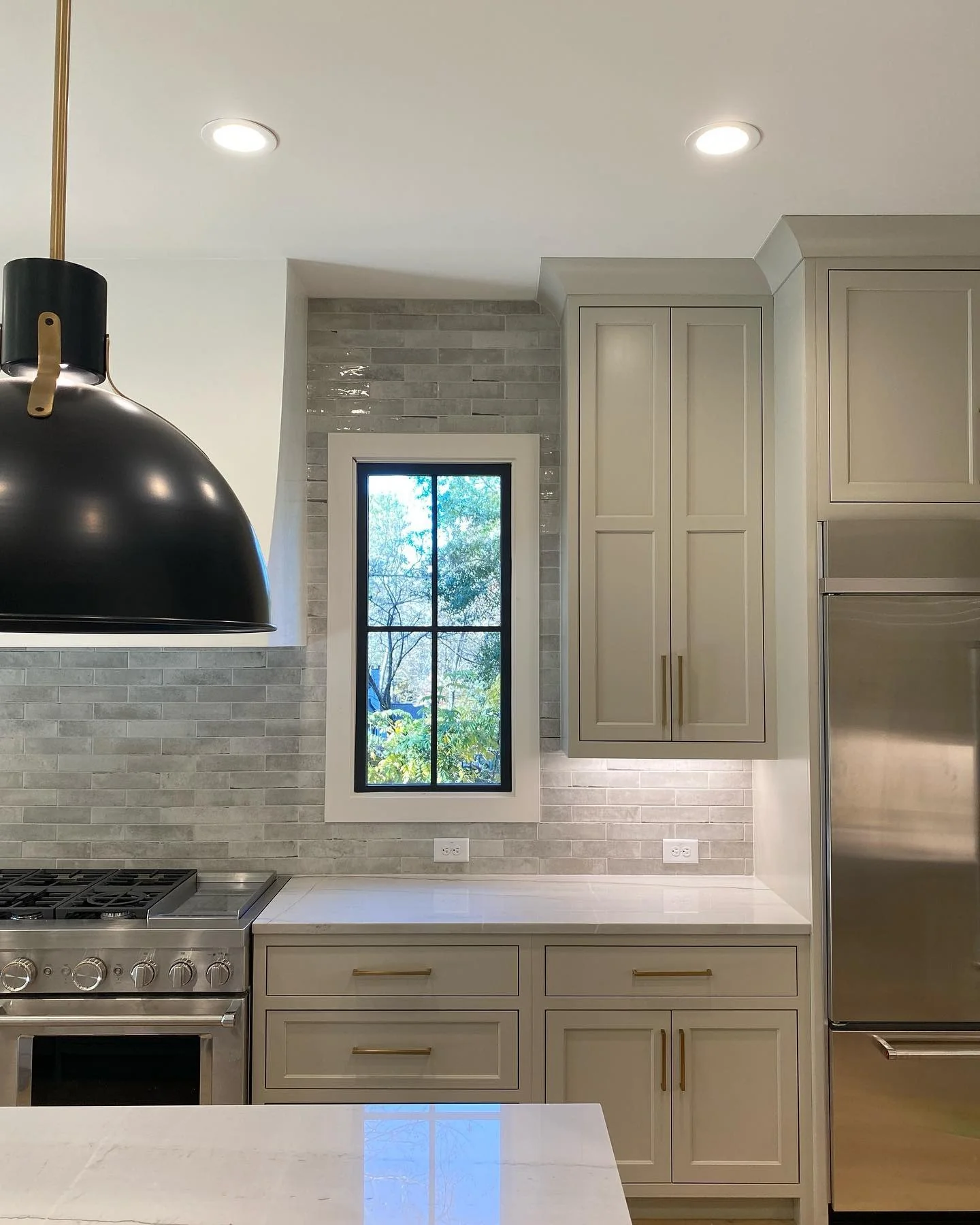 Subtle gray brick tile backsplash adds a soft, warm texture