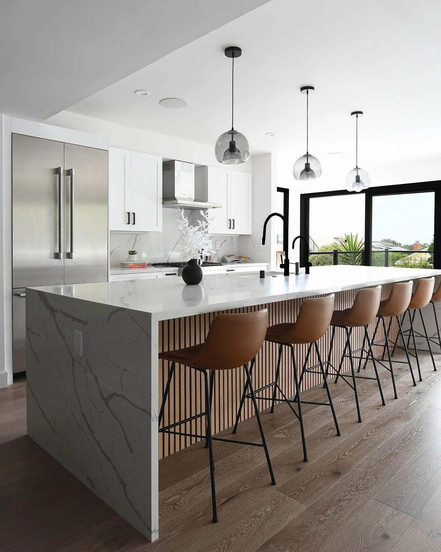 Vertical Wood Slat Island Adds Warm Texture to White Kitchen